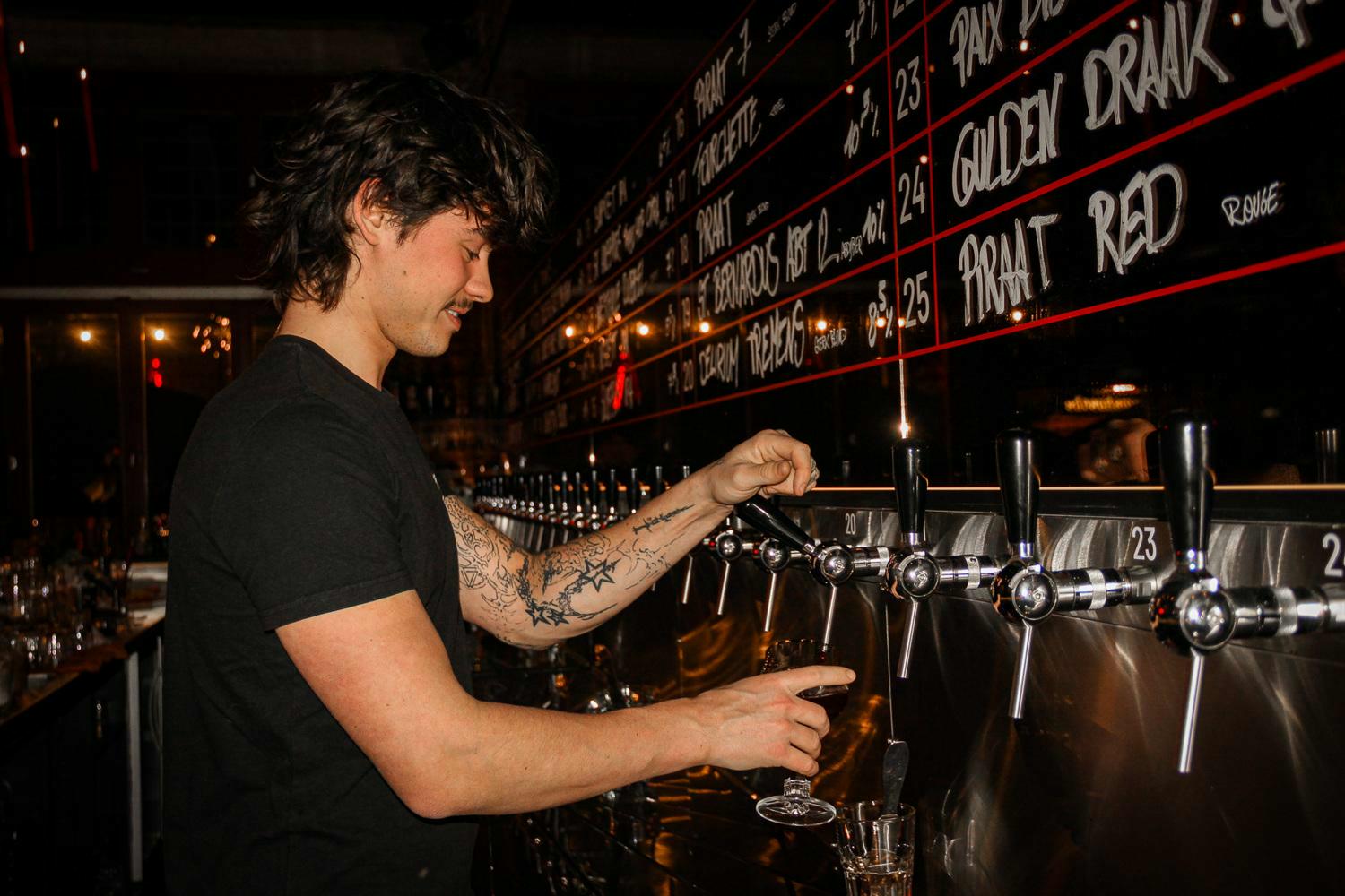 Barmedewerker tapt een pintje in het biercafé Dragòn in Gent.
